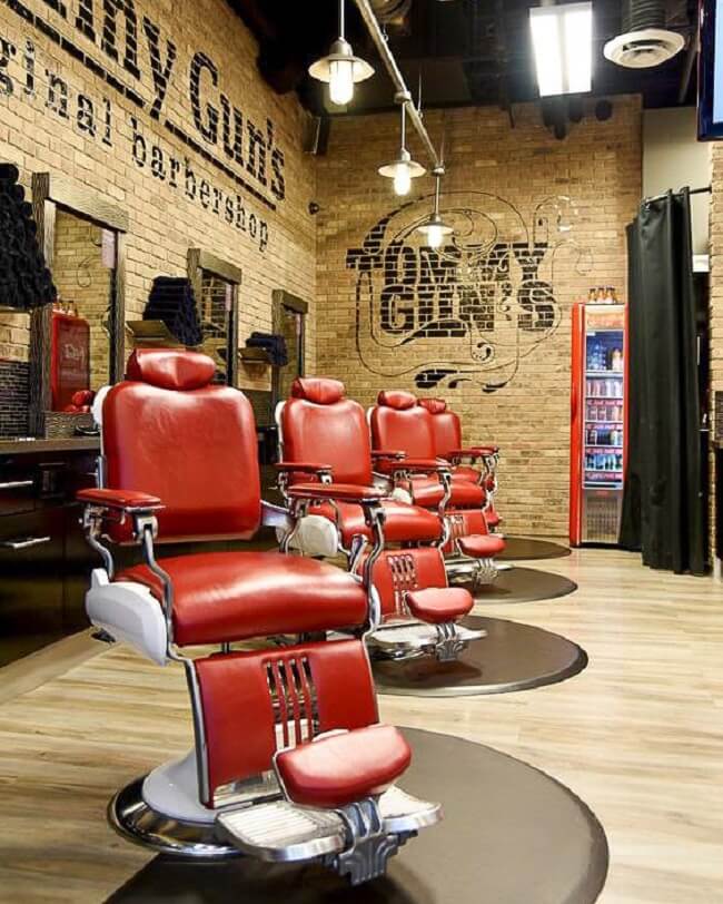 As cadeiras vermelhas se destacam na decoração da barbearia retrô