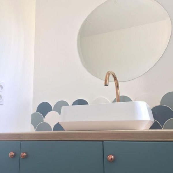 Banheiro azul com revestimento excama de peixe apenas em parte da parede