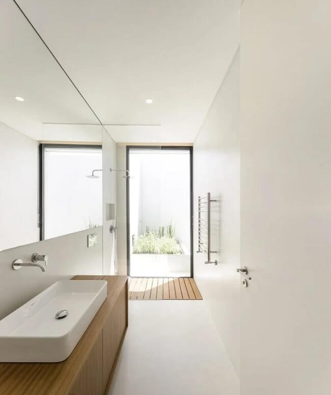 Banheiro sofisticado com cimento queimado branco e bancada planejada