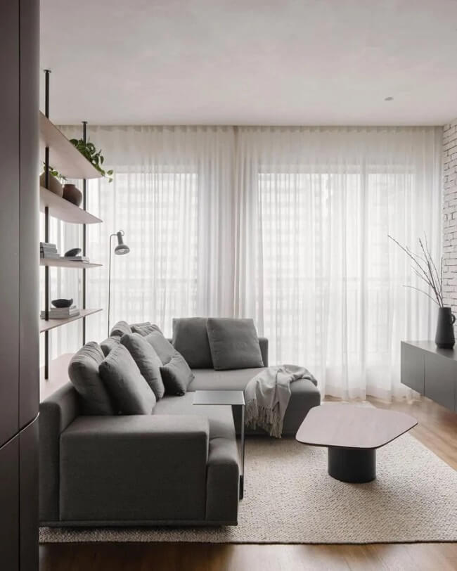 Cortina de tecido leve e sofá minimalista