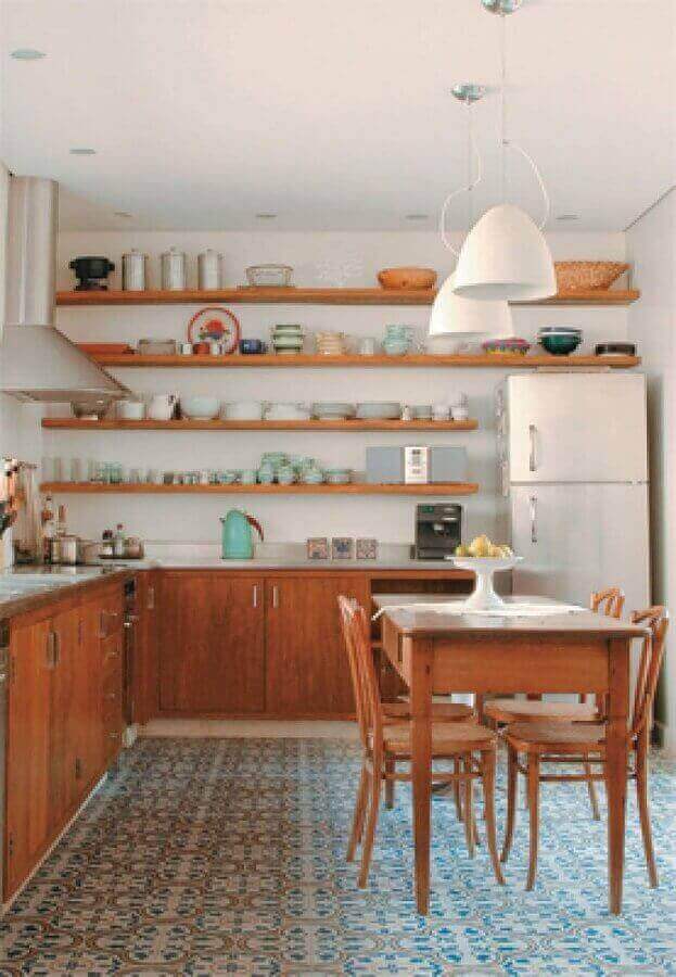 Cozinha com prateleira suspensa decorada com armários e mesa de madeira Foto Gustavo Calazans