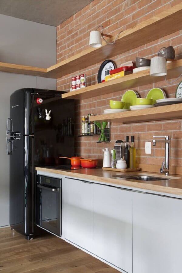 Decoração de cozinha com prateleira suspensa de madeira e parede de tijolinho Foto MCA Estúdio