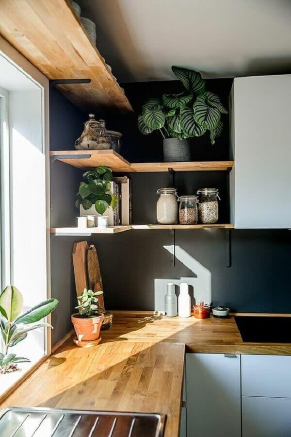 Decoração de cozinha com prateleiras de madeira de canto e parede preta