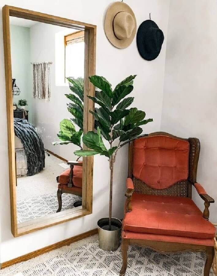 Decoração de quarto com poltrona antiga e espelho grande com moldura de madeira Foto Archzine