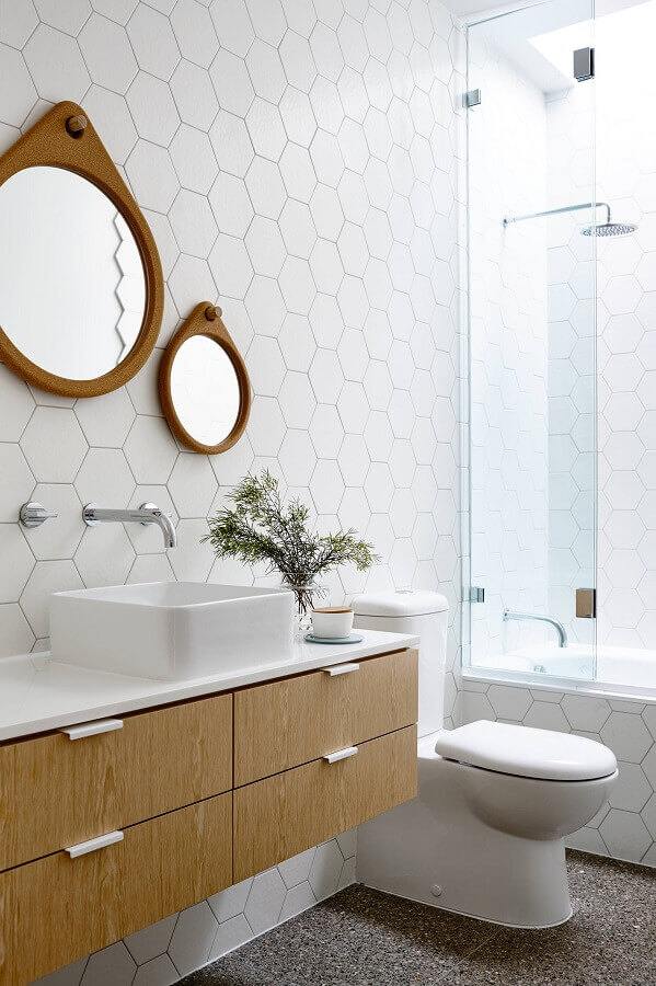 Espelho com moldura de madeira para banheiro branco decorado com revestimento hexagonal 