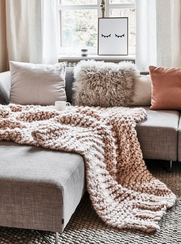 Itens de decoração de sala com sofá chaise e manta de crochê