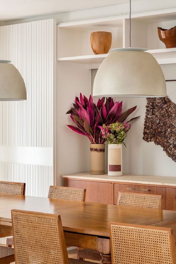 Itens de decoração para sala de jantar com buffet de madeira e vaso de flores