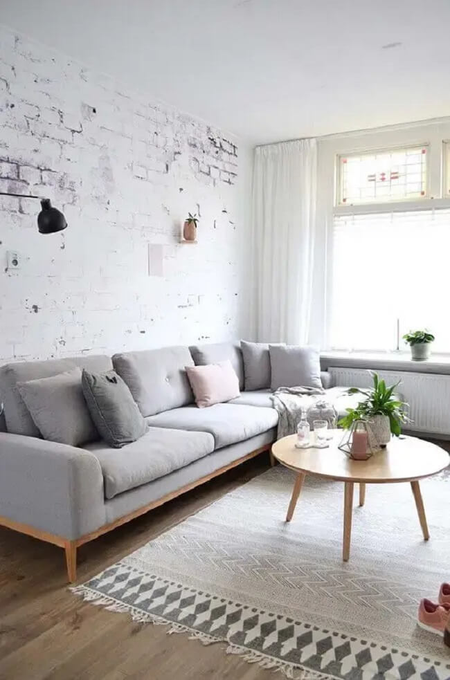 Parede de tijolinho aparente e sofá minimalista