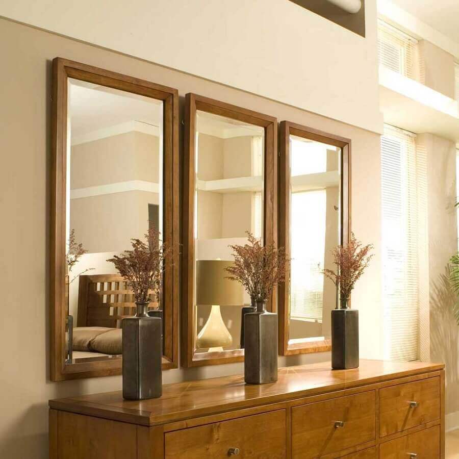Quarto decorado em cores neutras com cômoda e espelho com moldura de madeira Foto Total Construção