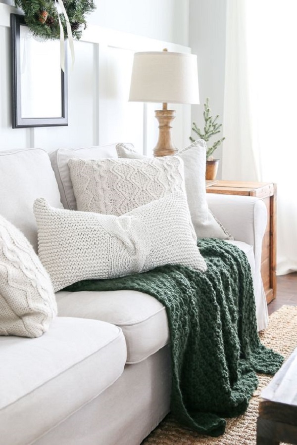 Sala clean com almofada de tricô e itens para decoração de sala aconchegantes