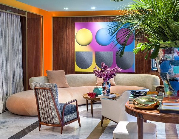 Sala moderna com sofá cor areia e decoração colorida