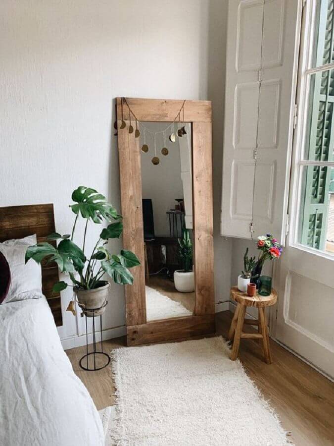 Vasos de plantas e espelho com moldura de madeira para decoração de quarto simples Foto HANNUN