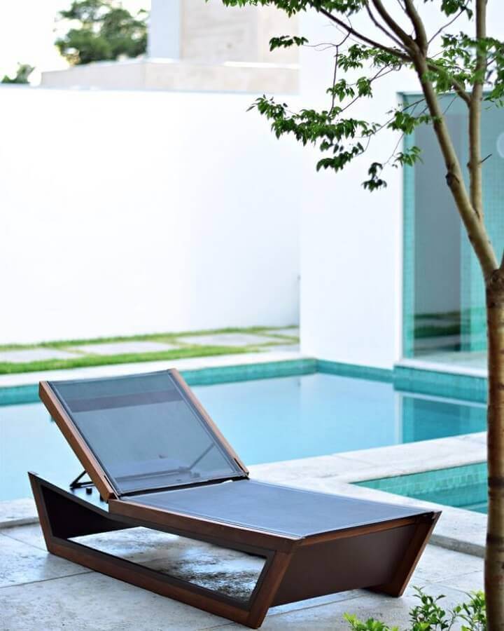 Área externa decorada com modelo moderno de espreguiçadeira de madeira para piscina Foto Mac Design