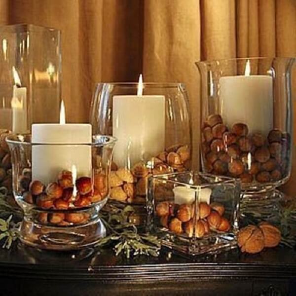 Arranjos de natal em vasos de vidro com velas e nozes