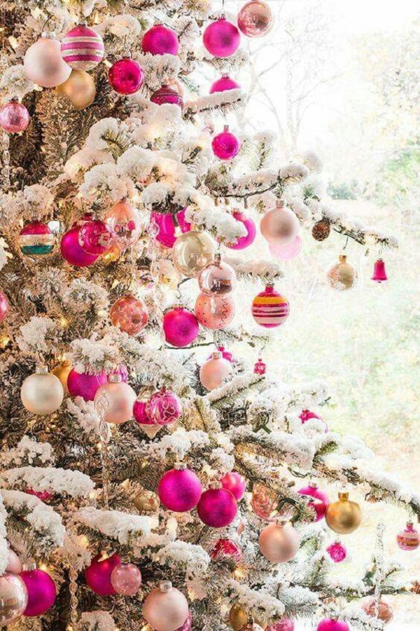 Árvore de natal nevada com bolas de natal em rosa