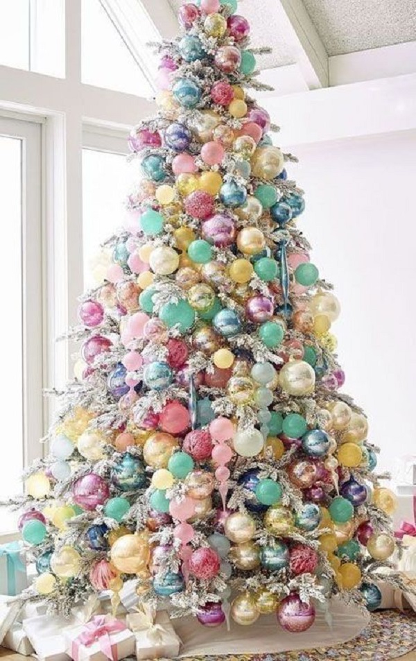 Árvore de natal nevada com enfeites coloridos para decoração alegre e colorida