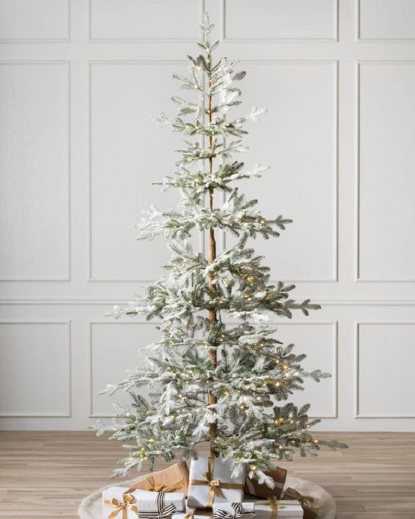 Árvore de natal nevada minimalista com presentes na decoração