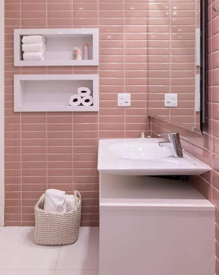 Banheiros com nichos embutidos decorado com revestimento rosa claro 