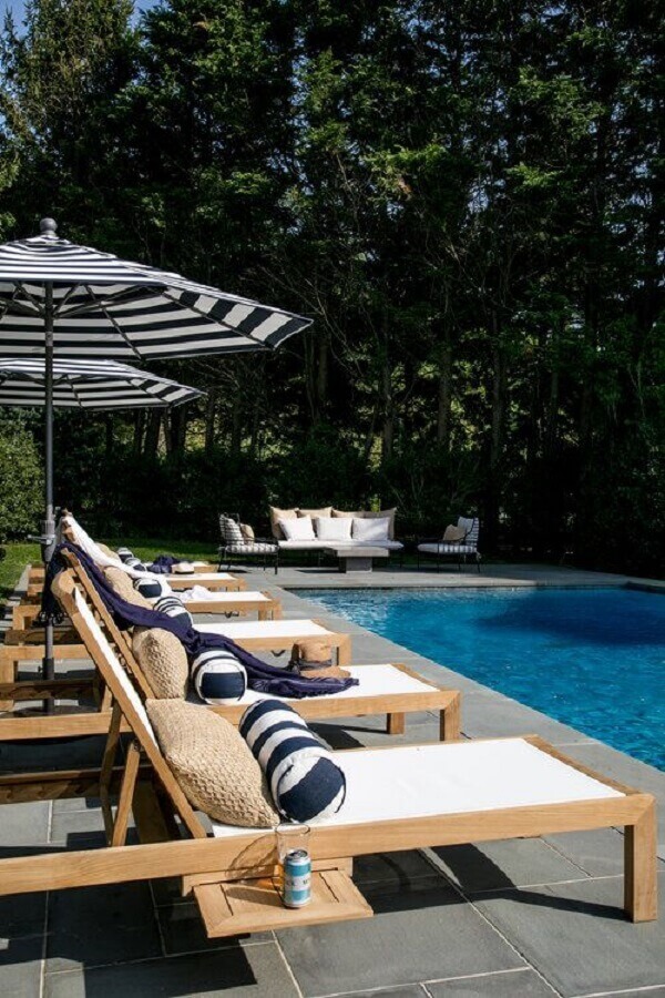 Guarda sol listrado para área externa decorada com almofada para espreguiçadeira de piscina