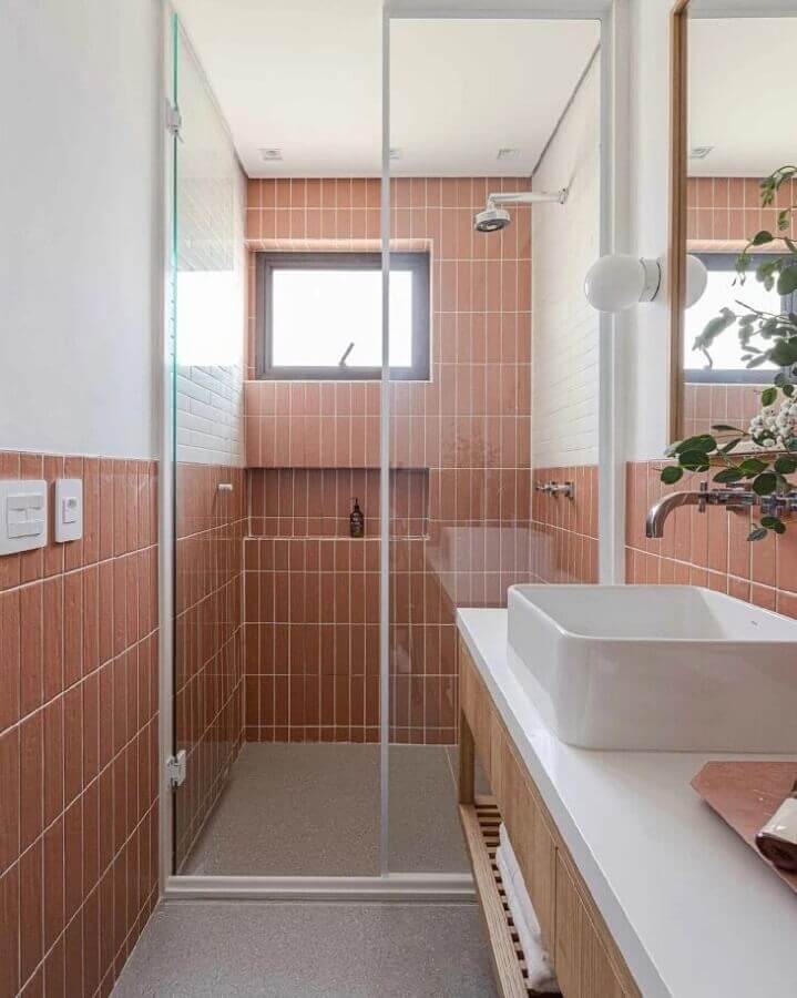 Decoração simples com revestimento rosa para banheiro pequeno com nicho embutido