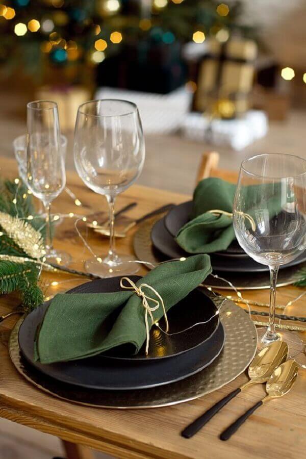 Mesa posta de ano novo moderna e sofisticada decorada com pratos pretos e talheres dourados