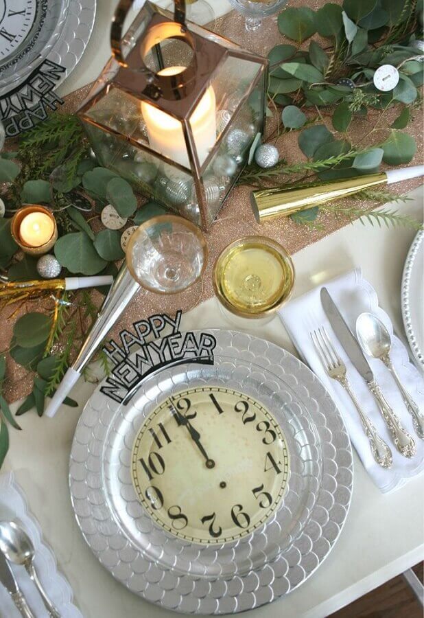 Decoração criativa para mesa posta ano novo moderna com detalhes em dourado e imagem de relógio no prato
