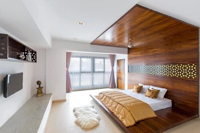 O revestimento de madeira serve como base para a cama oriental casal