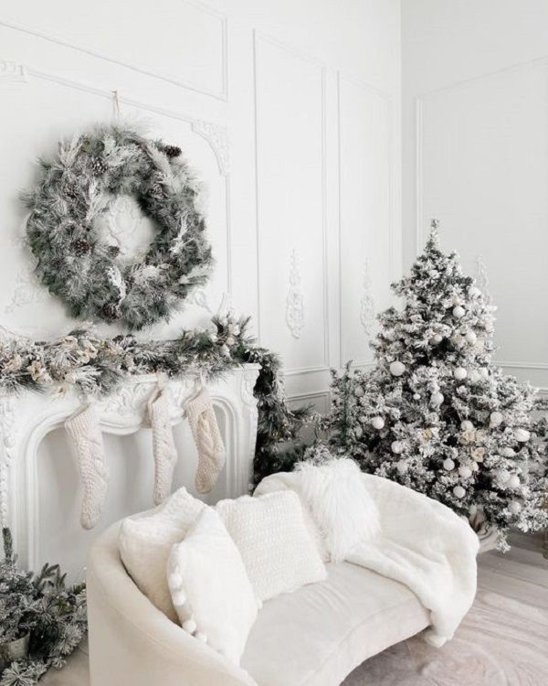 Sala branca decorada com árvore de natal nevada 