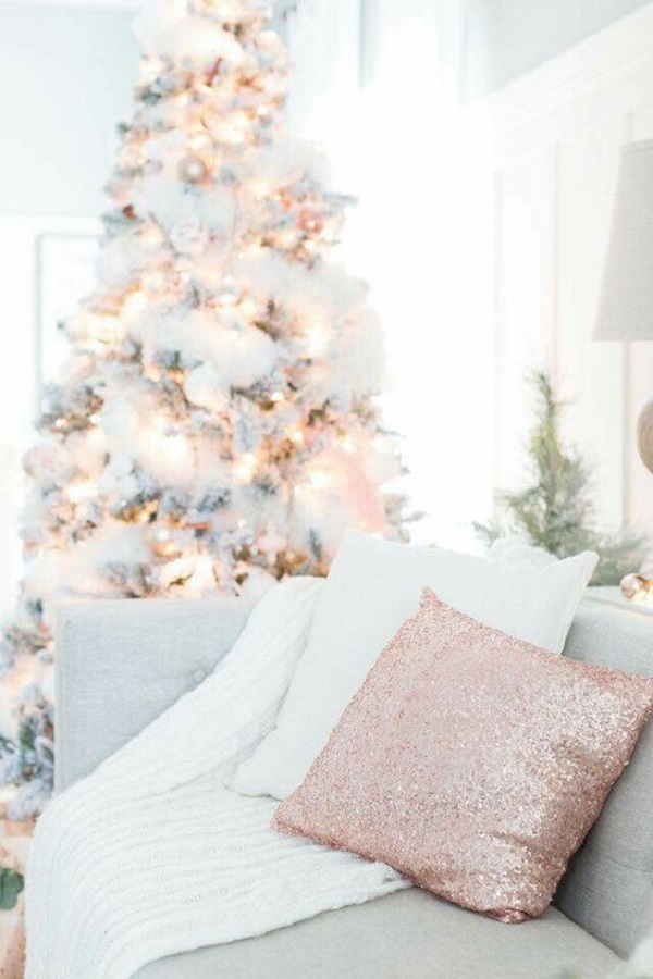 Sala rose gold com árvore de natal nevada e iluminada