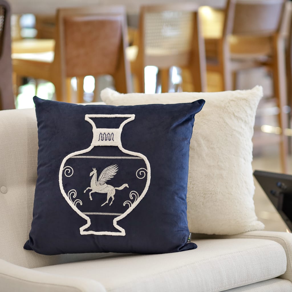 Almofada para sala: a almofada bordada azul marinho traz o clássico da decoração grega retratando as famosas jarras de cerâmica. Fonte - Luisa Decor