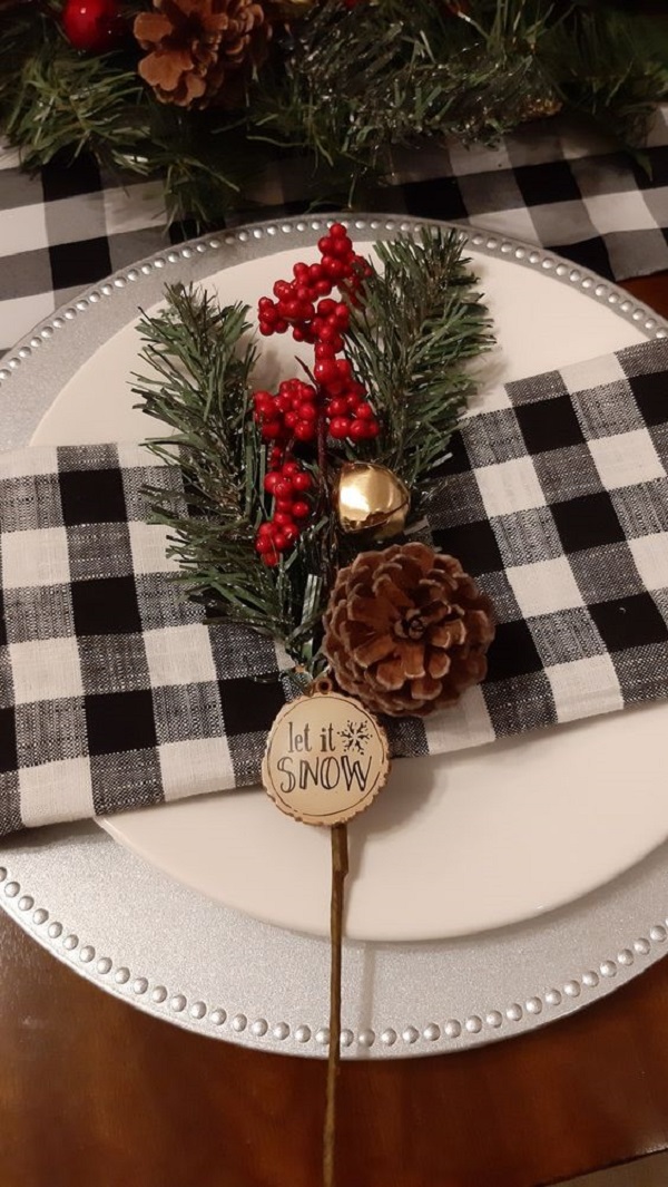 Arranjos natalinos na mesa de jantar decorando o guardanapo