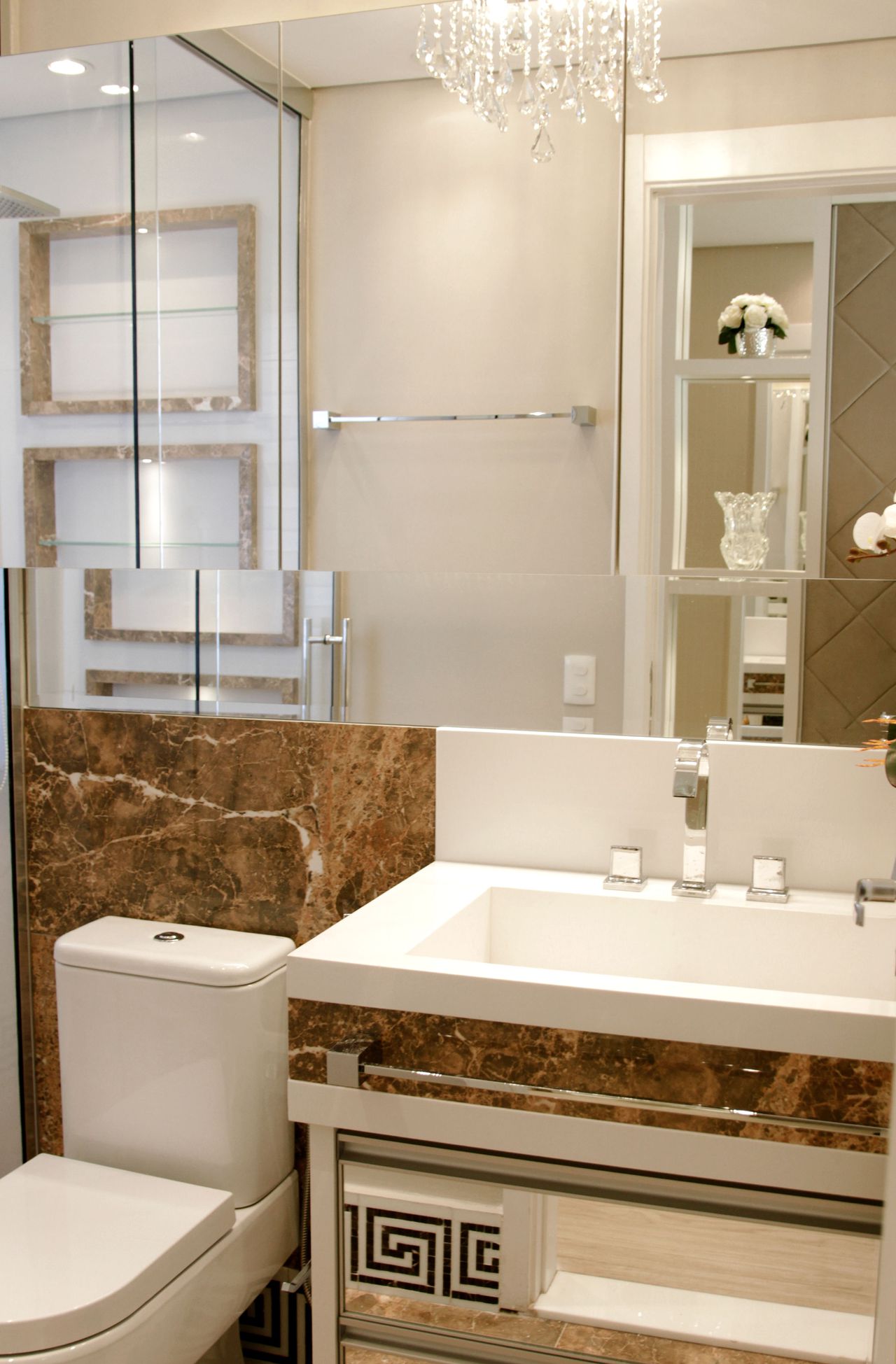 Banheiro com detalhes em mármore marrom e espelho na parede