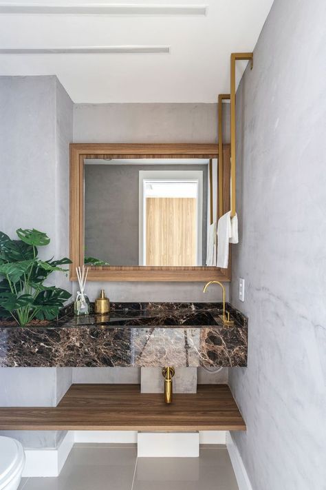 Banheiro com mármore marrom e torneira dourada
