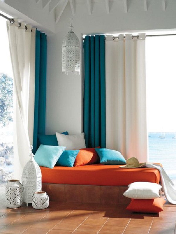 Decoração com cortina azul e sofá laranja