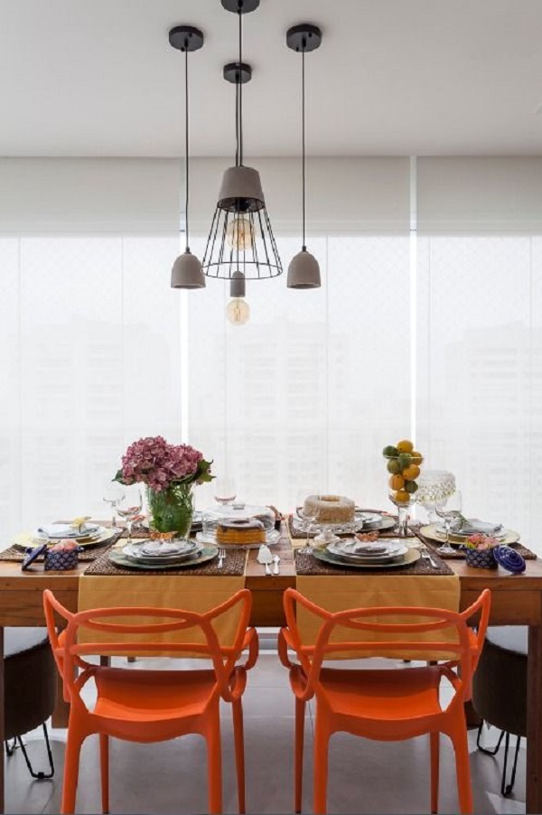 Mesa de jantar com cadeiras em tons de laranja 