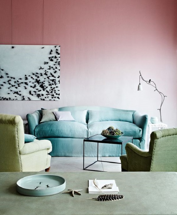 Sala com parede ombre em tons de rosa e sofá azul
