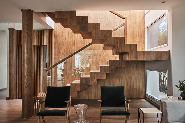 Escadas para casa de madeira com cadeiras decorativas pretas